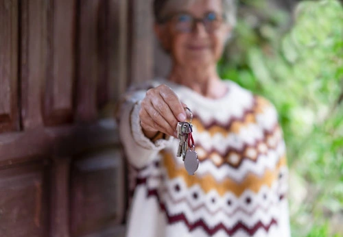 Personne âgée qui tend une clé pour ouvrir la porte de chez soi, Villa d'Hustey Saint Paul Lès Dax